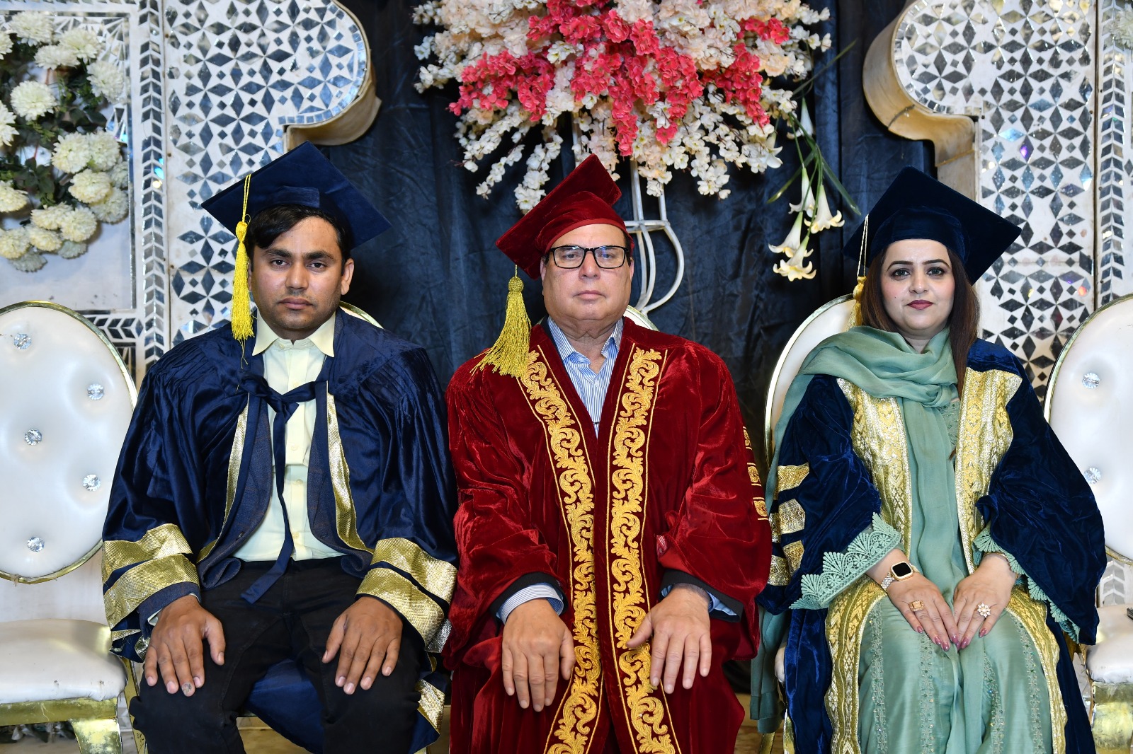 The President with two graduates in ceremonial robes